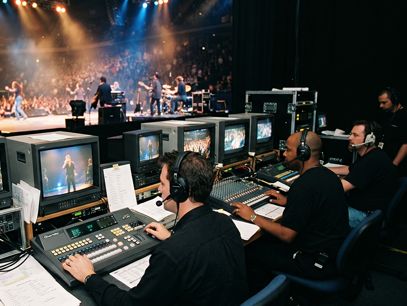Technical crew directing and switching a live concert from the backstage control area