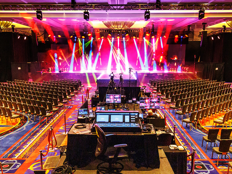 Live event venue prepared with stage lighting, cameras, and a production control station