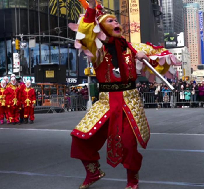 Monkey King performer in a red and gold costume during a Times Square flash mob