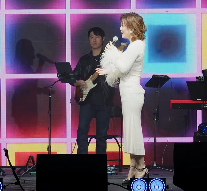 Female singer performing with a guitarist during the 2025 Power Of Live Concert in Los Angeles
