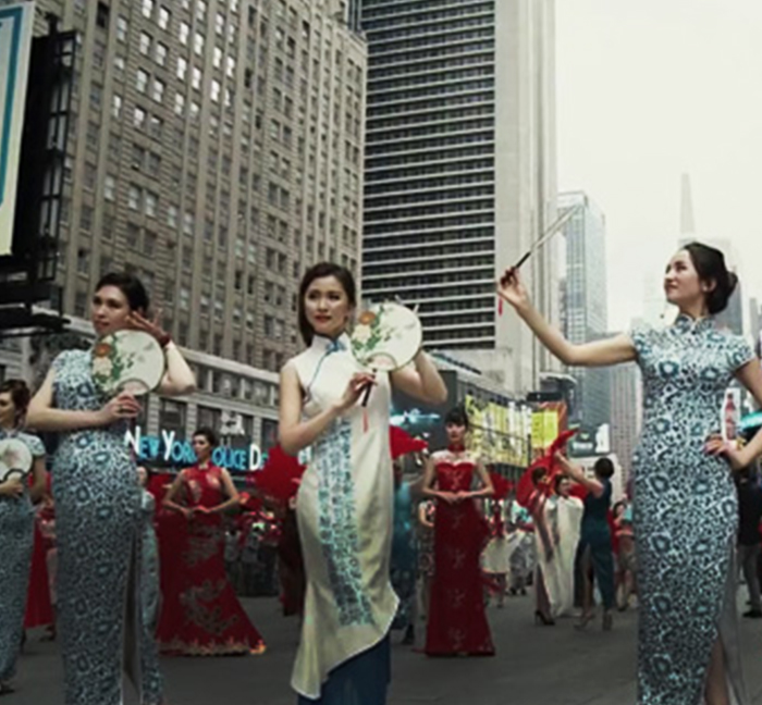 Women wearing traditional qipao dresses performing in a Times Square parade
